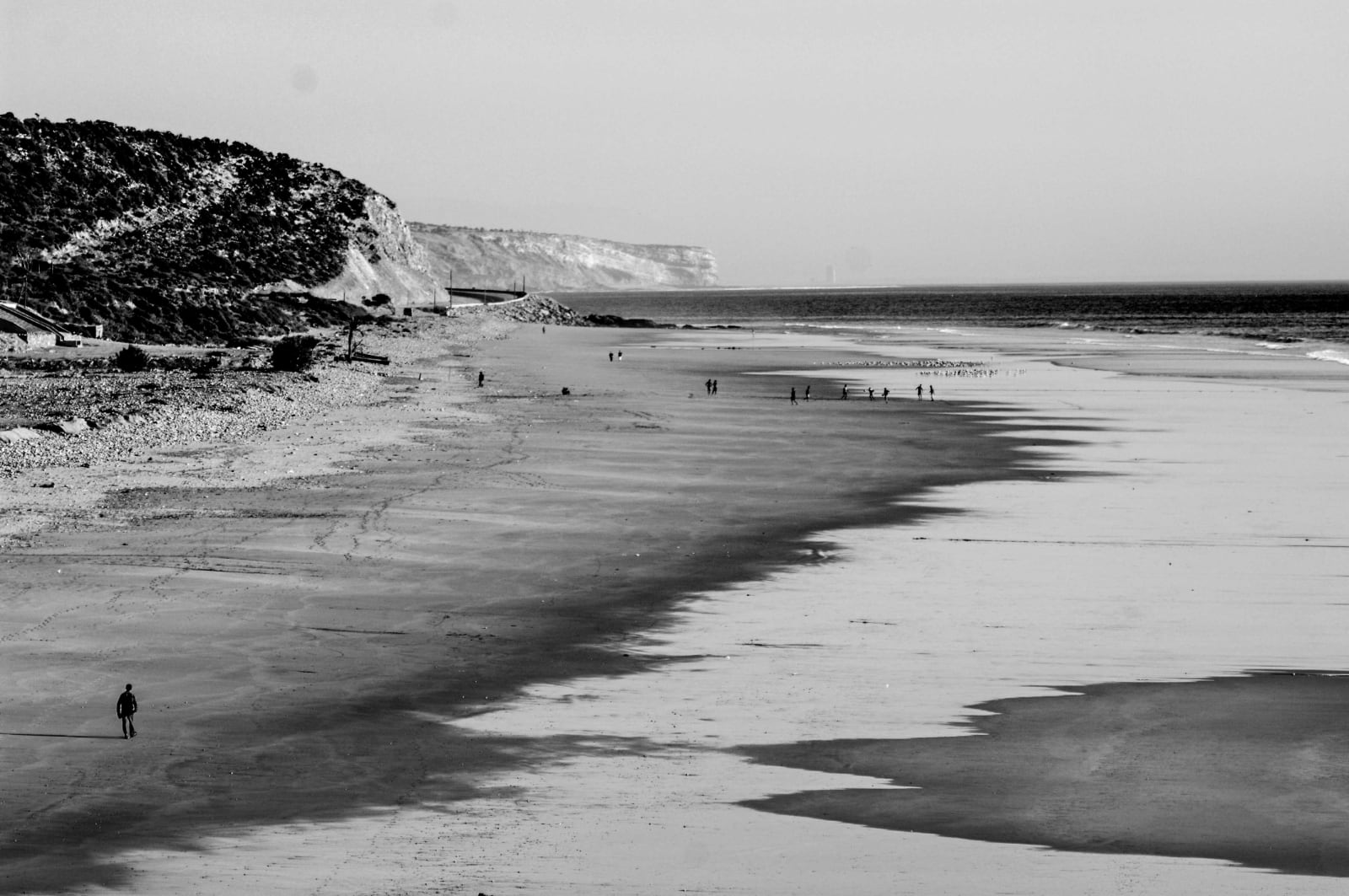 Panorama di una costa che potrebbe essere Normandia, con un uomo che cammina vicino al mare